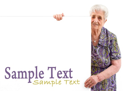 Portrait of a happy senior woman holding blank billboard against white background の写真素材