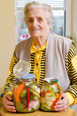 Happy old gray-haired woman with veggiesの写真素材