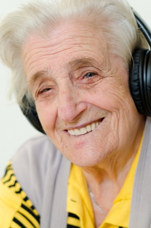 portrait of a senior woman listening to music on white backgroundの写真素材