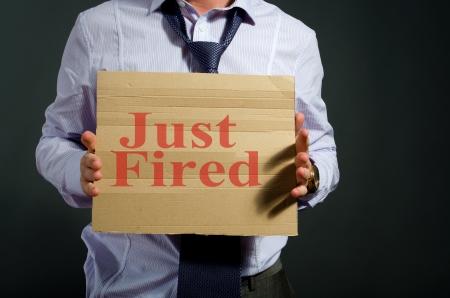 fired employee holding just fired sign in handの写真素材