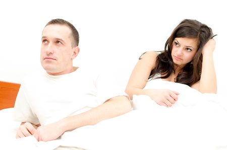 A young couple in bed having problemsの写真素材
