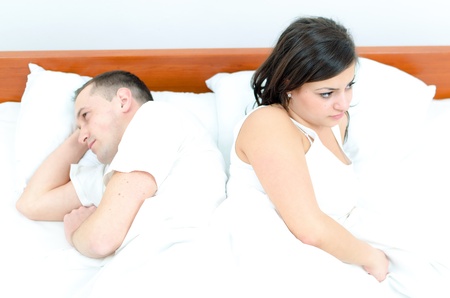A young couple in bed having problemsの写真素材