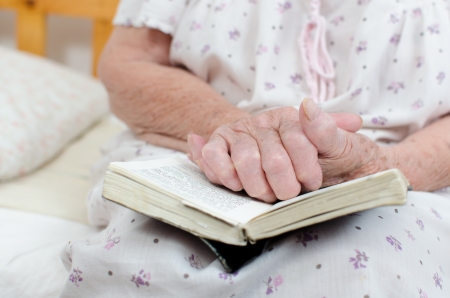 Closeup of senior woman's hands on bibleの写真素材
