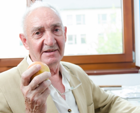 Closeup profile on a smiling old man with appleの写真素材