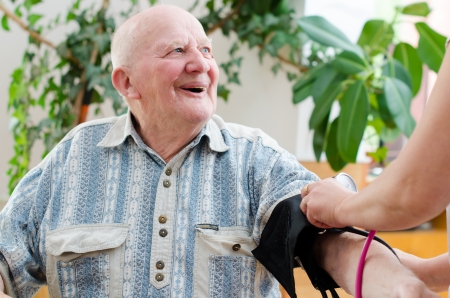 nurse checking senior man blood pressure の写真素材