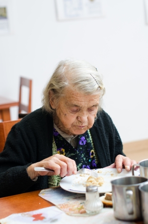 senior woman eating her lunch at homeの写真素材