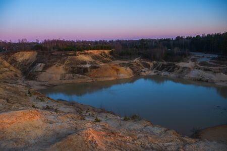 Sand mountains with small coniferous trees. The lake in the middle of the mountains. Beautiful natural landscape.の写真素材
