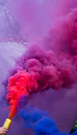 Using a smoke bomb. Colorful smoke from a smoke bomb. Blue, pink, purple, green colours.の写真素材