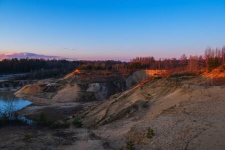 Wild abandoned sand quarry. Trees and a lake in an old sandy quarry.の写真素材