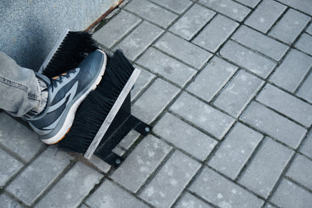 A man cleans his shoes. Two brushes for cleaning shoes. A man wipes his leg.