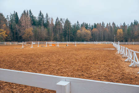 Pure white racetrack against the backdrop of a beautiful autumn forest. White fence in the background of nature.の写真素材