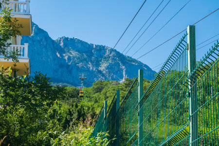 The yellow ski elevator descends from the mountains, against the backdrop of mountains and...