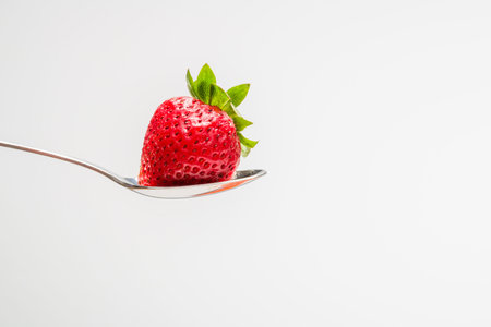 Strawberry in a spoon with a white background. With room for text.の写真素材