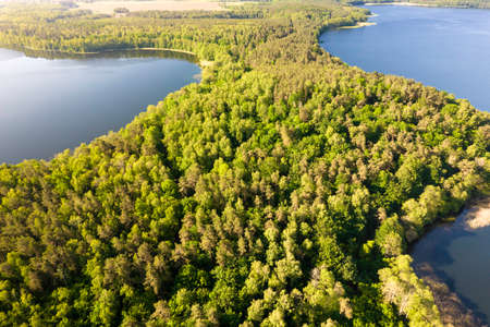 View from the top of Wierzchowo lake in Poland. Green forest surrounding the lake and clear blue water Rural landscape in Poland.の写真素材