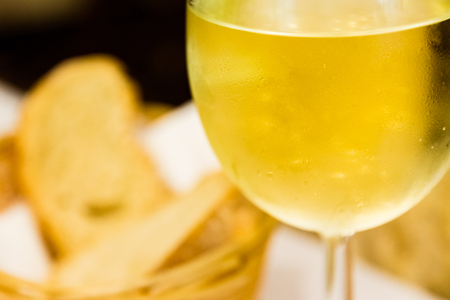 Blurred White Wine Focus on Glass Droplets in Restaurant Atmosphereの写真素材