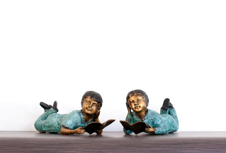 Ornamented Bronze figures of  two chidren  reading booksの写真素材