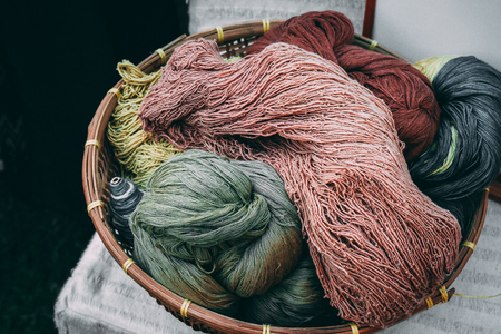 Basket of colorful yarn in a gloomy toneの写真素材