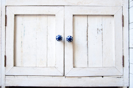 White vintage wooden cupboard with blue knobsの写真素材