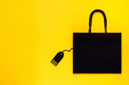 Shopping bag that have price tag with word on yellow background for Black Friday shopping concept.の写真素材