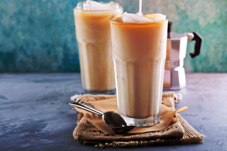 Iced coffee with milk in tall glasses on the tableの写真素材
