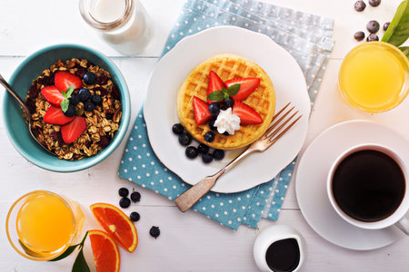 Breakfast waffles with fresh berries stacked on a plateの写真素材