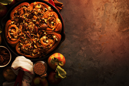 Cinnamon rolls with apples, caramel and pecan, fall baking concept overhead shot with copy spaceの写真素材