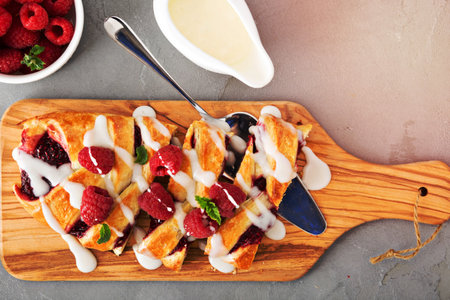 Braided raspberry danish with glaze and fresh berriesの写真素材