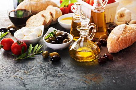 Olive oil in vintage bottles with black and green olives and italian cuisine ingredients copyspace on rustic backgroundの写真素材