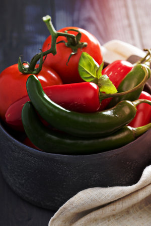 Green and red hot pepper in a bowlの写真素材