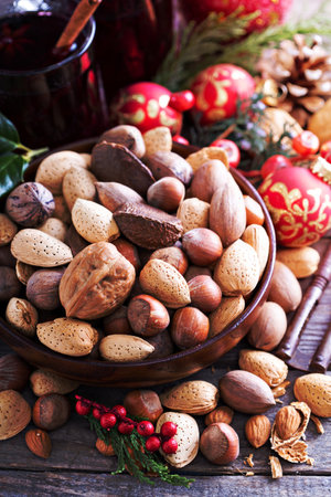 Variety of nuts with shells in a brown bowlの写真素材