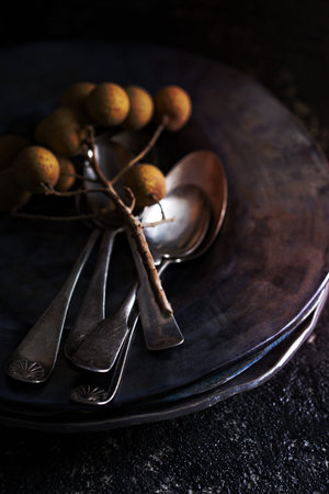 Black handmade ceramic plates with old vintage spoonsの写真素材