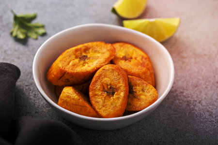 Fried plantains with fresh lime in the background, carribean cuisineの写真素材