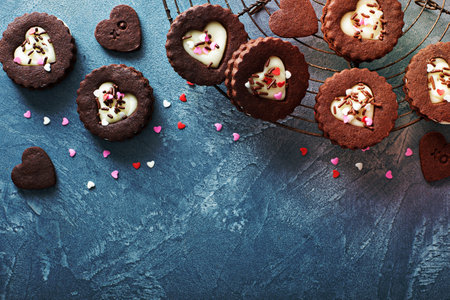 Heart shaped chocolate cookies with cream filling for Valentines day on a baking rack, sweet treats backgroundの写真素材