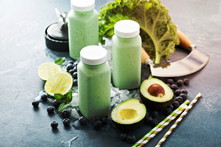 Green smoothies with kale and avocado in small bottles to goの写真素材