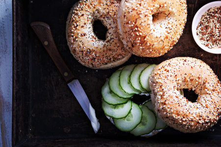 Everything bagels with seeds served with cream cheese and cucumberの写真素材