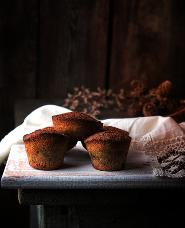 baked small cupcakes with dried fruits on a white wooden board, top viewの写真素材