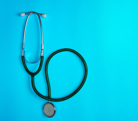 green medical stethoscope on blue background, close up, copy spaceの写真素材