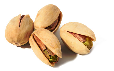 Fried salted pistachios in shell on white isolated background, delicious snackの写真素材