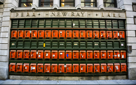 many green and orange mailboxs on the side of a building in new yorkの素材