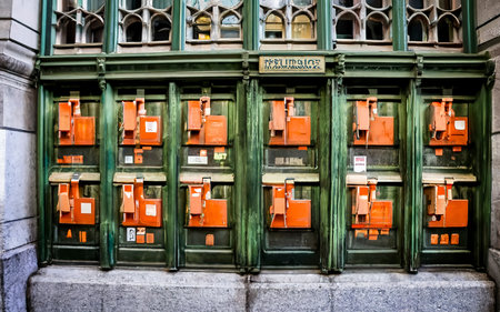 many green and orange mailboxs on the side of a building in new yorkの素材