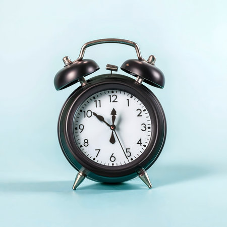 Black alarm clock set on blue background with copy space. Time concept.の素材