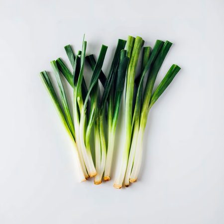 Minimal flat lay looking leeks view during slice progress over whiteの素材