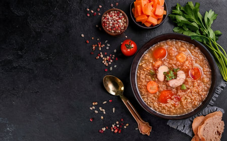 Barley soup with carrots, tomato, celery and meat on a dark backgroundの素材