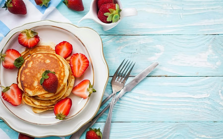 Pancakes with fresh strawberry on a blue wooden backgroundの素材