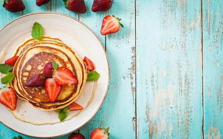 Pancakes with fresh strawberry on a blue wooden backgroundの素材