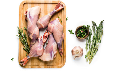 Raw Duck legs on a wooden tray. Isolated on white backgroundの素材