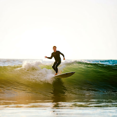 Surfer riding a long wave light play on water surface adding dramaの素材