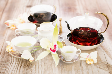 Black and green tea with orchid flower on a wooden backgroundの素材