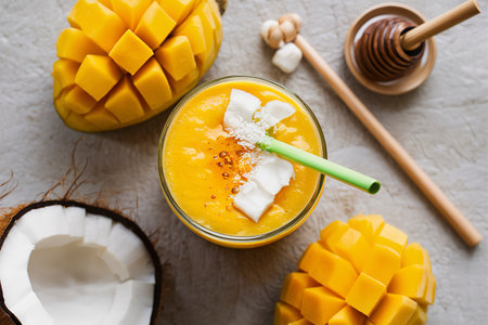Tropical mango smoothie with honey and coconut overhead shotの素材