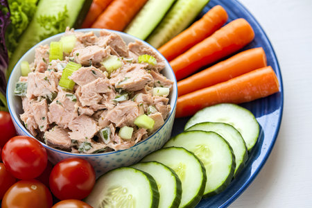 A photo of a plate with a tuna salad and a tasty selection of vegetablesの写真素材